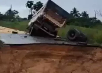 Um caminhão carregado quase não consegue passar e acabou tombando logo após a pista se romper (Reprodução / Redes Sociais)