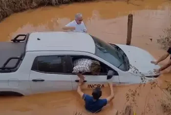 Três homens auxiliam os servidores a saírem de dentro do automóvel pelas janelas da frente, juntamente com os pertences que possuíam. (Reprodução/ Redes sociais)