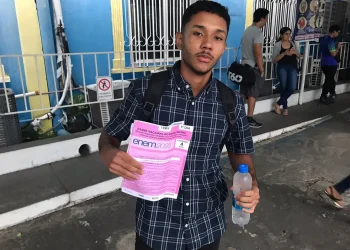 Estudante segura prova na cor rosa do Enem 2023. — Foto: Hariel Fontenelle / g1