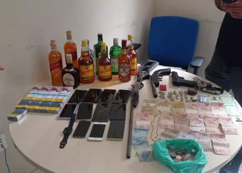 Com os dois suspeitos, os policiais encontraram mais de R$ 200 em espécie, uma cédula de 100 kwanzas (moeda angolana), drogas, armas de fogo, cordão, relógio, cartões de crédito e 12 celulares, além de duas motos que teriam sido usadas pela dupla no arrastão. (Reprodução / Redes sociais)