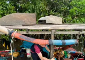 Imagem mostra policiais civis em cima de uma embarcação de madeira (Foto: Divulgação | Agência Pará)