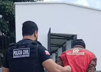 Suspeito sendo conduzido para a delegacia. (Foto: Polícia Civil)