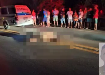 A imagem mostra o corpo da vítima do acidente, Sivaldo Ribeiro de Sousa, de 42 anos, jogado na pista da BR-422 e sendo observado por curiosos. (Foto: Reprodução | Correio de Carajás)