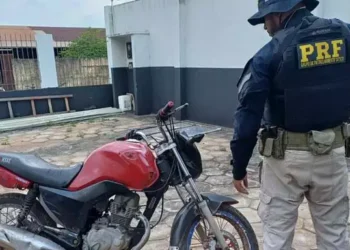 A imagem mostra um policial rodoviário federal com a motocicleta que havia sido roubada. (Foto: Divulgação | PRF)
