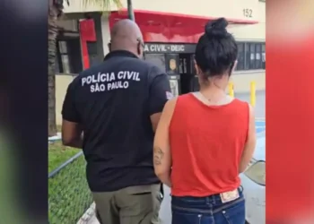 A imagem em destaque mostra um policial civil de São Paulo conduzindo uma das suspeitas presas na operação "Velozes e Furiosos" até a delegacia. (Foto: Divulgação | PC)