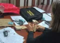 A imagem em destaque mostra uma policial federal segurando um rolo de dinheiro encontrado durante a operação. (Foto: Divulgação | Ascom PF)