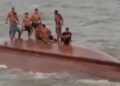 Pescadores ficaram em pé e sentados no casco do barco enquanto tripulantes de outra embarcação tentavam resgatá-los. — Foto: Reprodução / Redes sociais